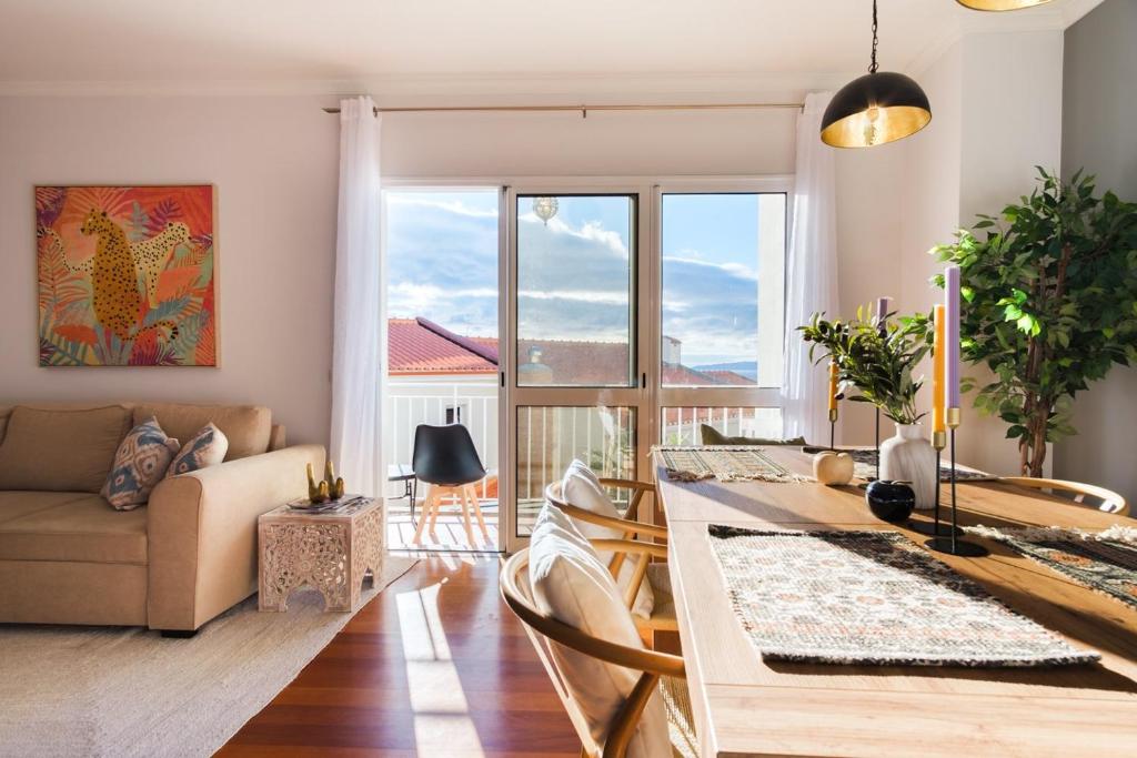 a living room with a table and a couch at GuestReady - Paradise home in Caniço in Caniço