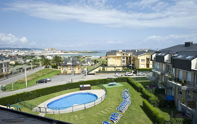 a view of a pool with lawn chairs and buildings at Apartamento en Playa de Altar in Barreiros