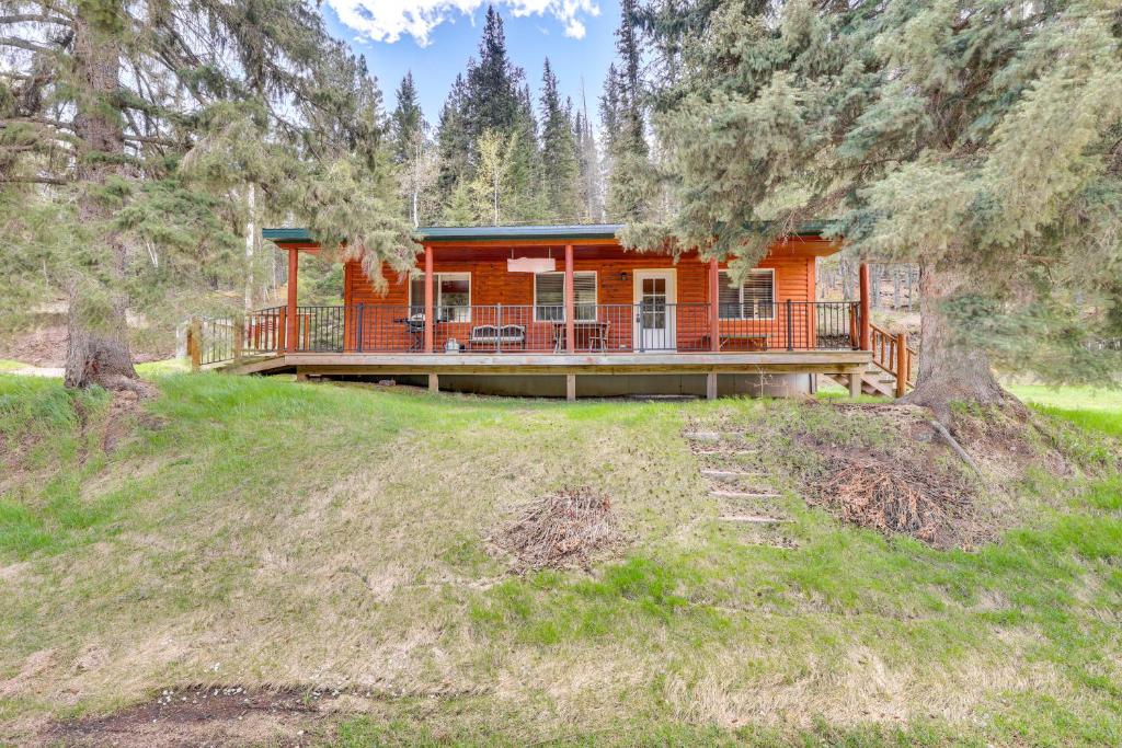 a log cabin in the woods with a porch and deck at Pets Welcome Cozy Cabin with Deck in Deadwood! in Deadwood