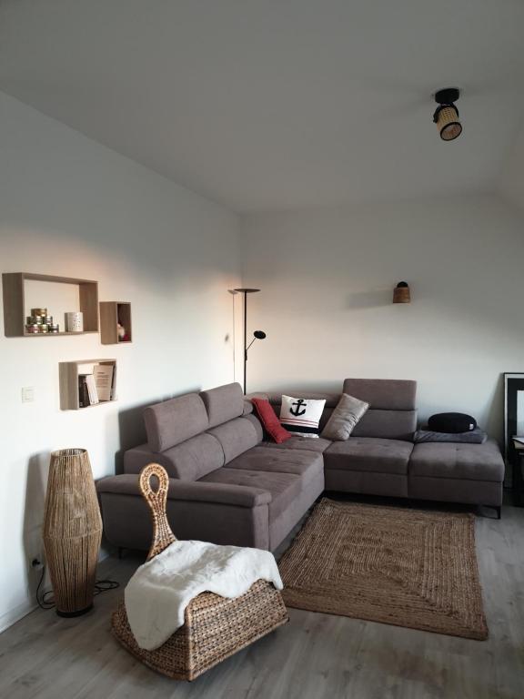 un salon avec un canapé gris et une table dans l'établissement bel appartement 4 personnes, à Port-en-Bessin-Huppain