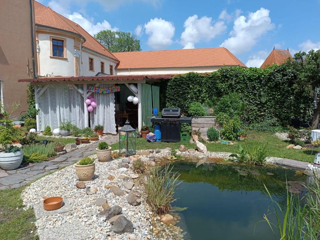 a garden with a pond in front of a house at Apartmány u sv. Michaela in Kadaň