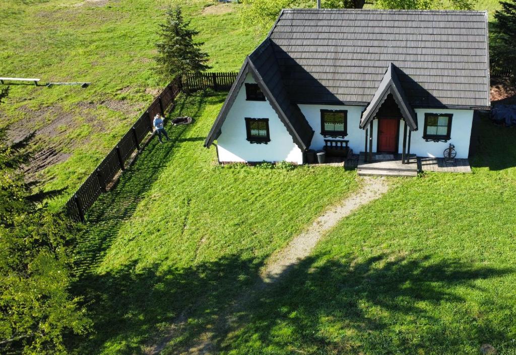 eine Aussicht auf ein Haus auf einem Grashügel in der Unterkunft Szczęśliwy Domek in Wetlina