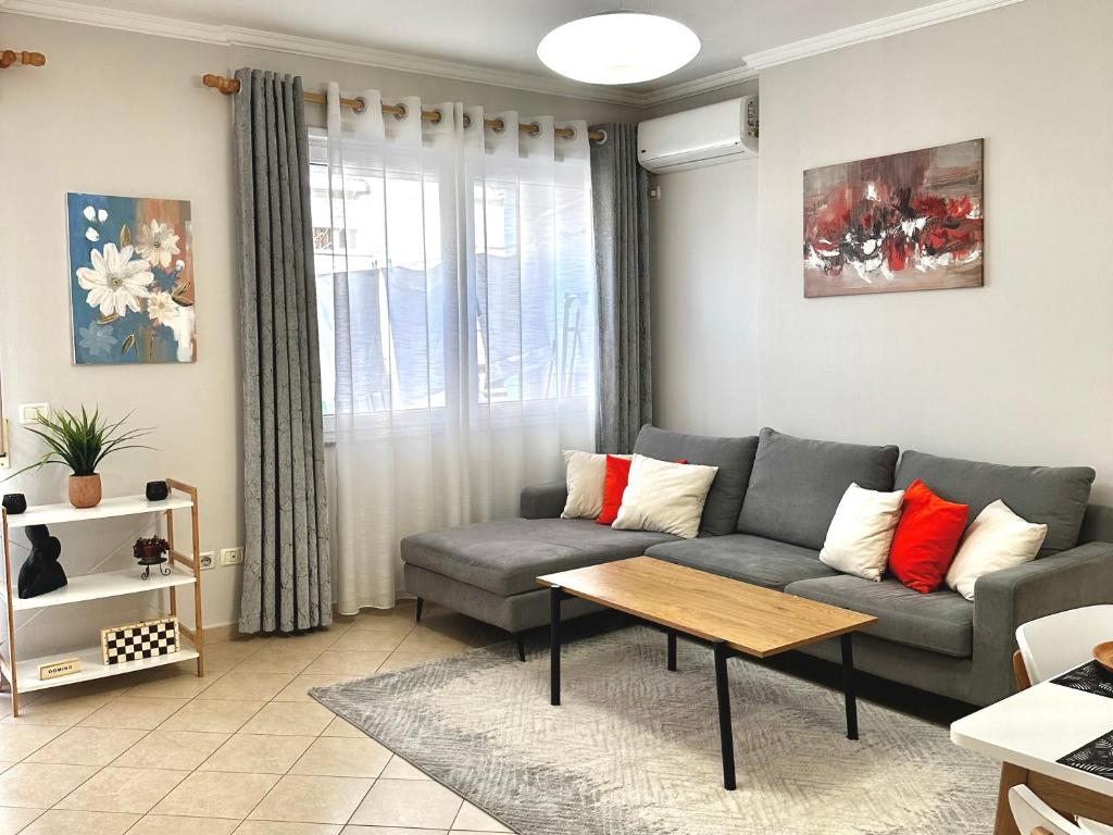 een woonkamer met een bank en een tafel bij Quiet & spacious city center apartment - 4 min walk in Tirana