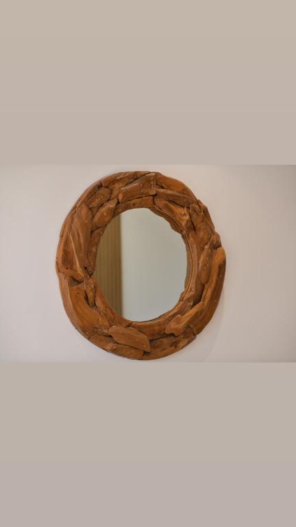 a wooden ring shaped mirror on a white wall at Kompleksi Turistik DEA in Shkodër