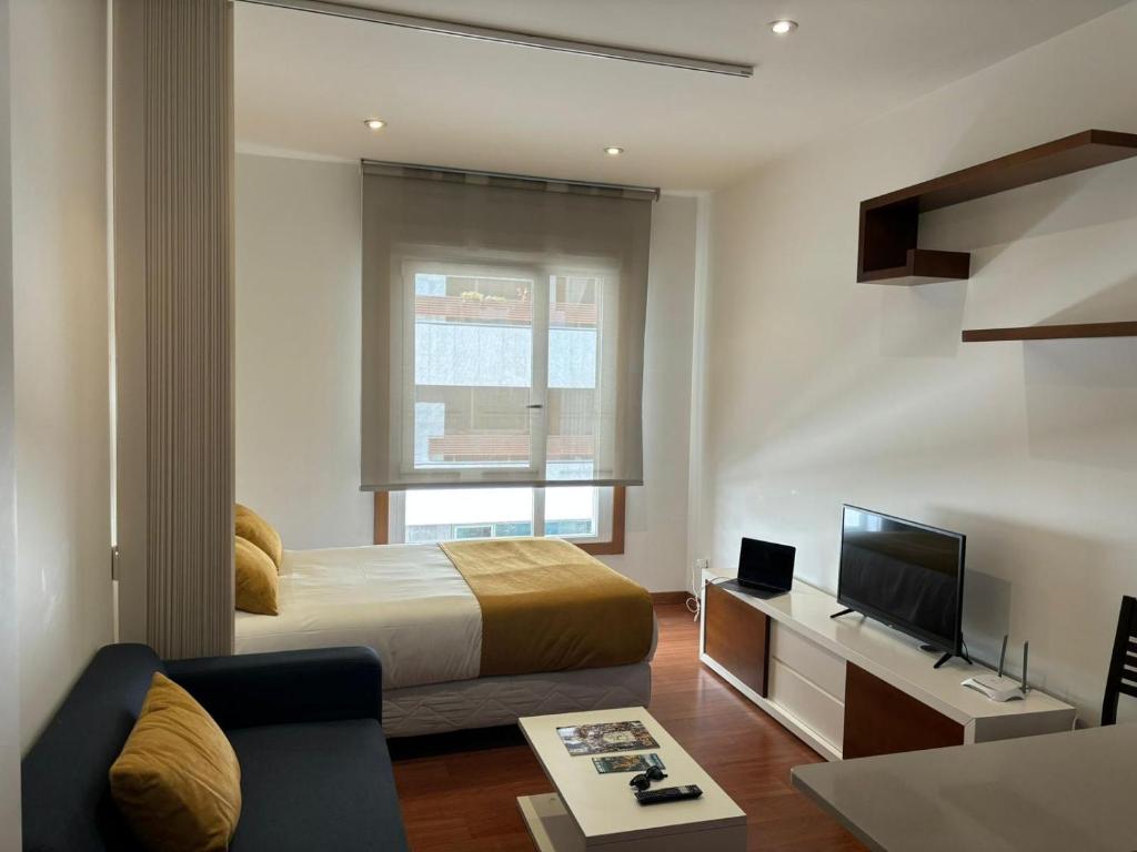 a hotel room with a bed and a television at Vigo Center Rooms in Vigo