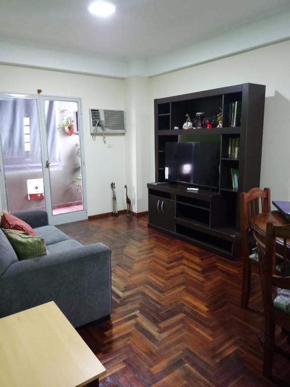a living room with a couch and a flat screen tv at Rincón Verde 1 in San Miguel de Tucumán