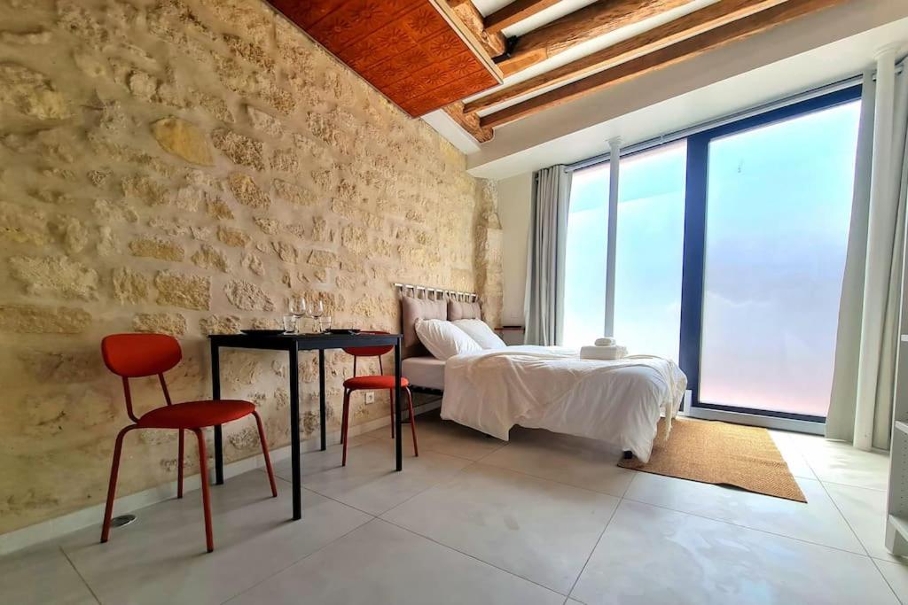 une chambre avec un lit, une table et des chaises dans l'établissement Studio de charme, à Fontenay-aux-Roses