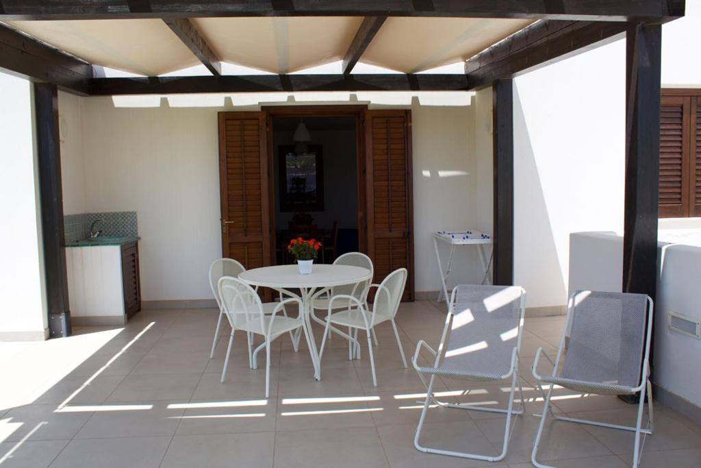 a patio with a table and chairs on a porch at Le Casette a Favignana in Favignana