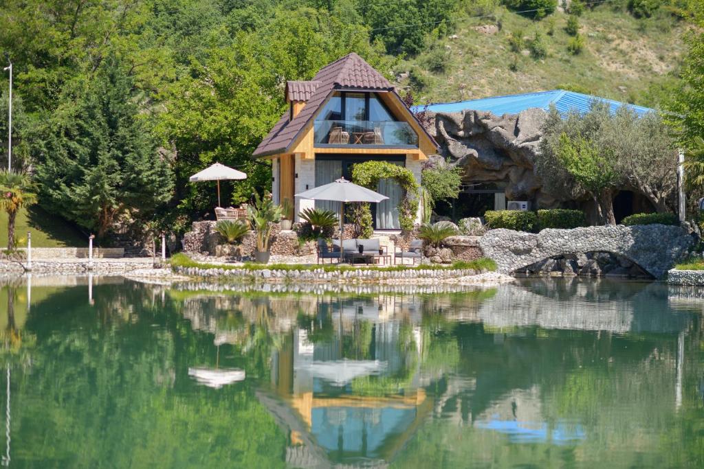 a house sitting on top of a large body of water at Kompleksi Turistik DEA in Shkodër
