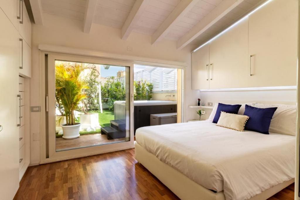 a bedroom with a large bed and a large window at Attico New Bussola Cagliari in Cagliari