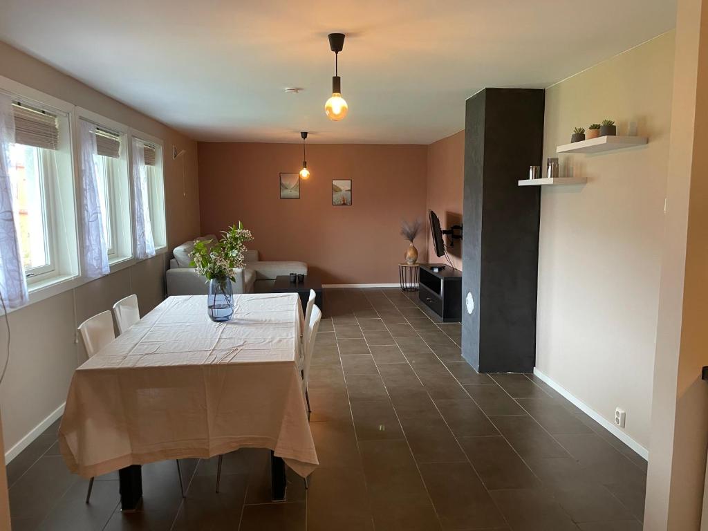 a dining room with a table with a vase on it at Slinningen Apartment with free parking in Ålesund