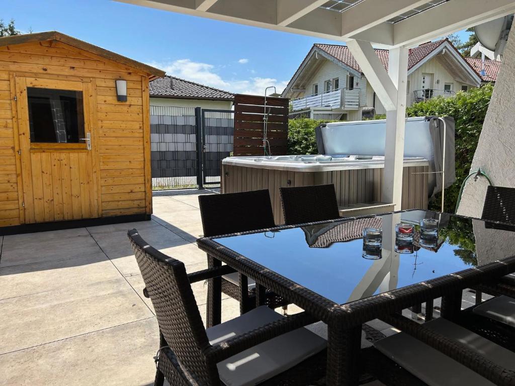 a patio with a table and chairs and a hot tub at Ferienhaus Andrea mit Whirlpool und Sauna in Rimsting