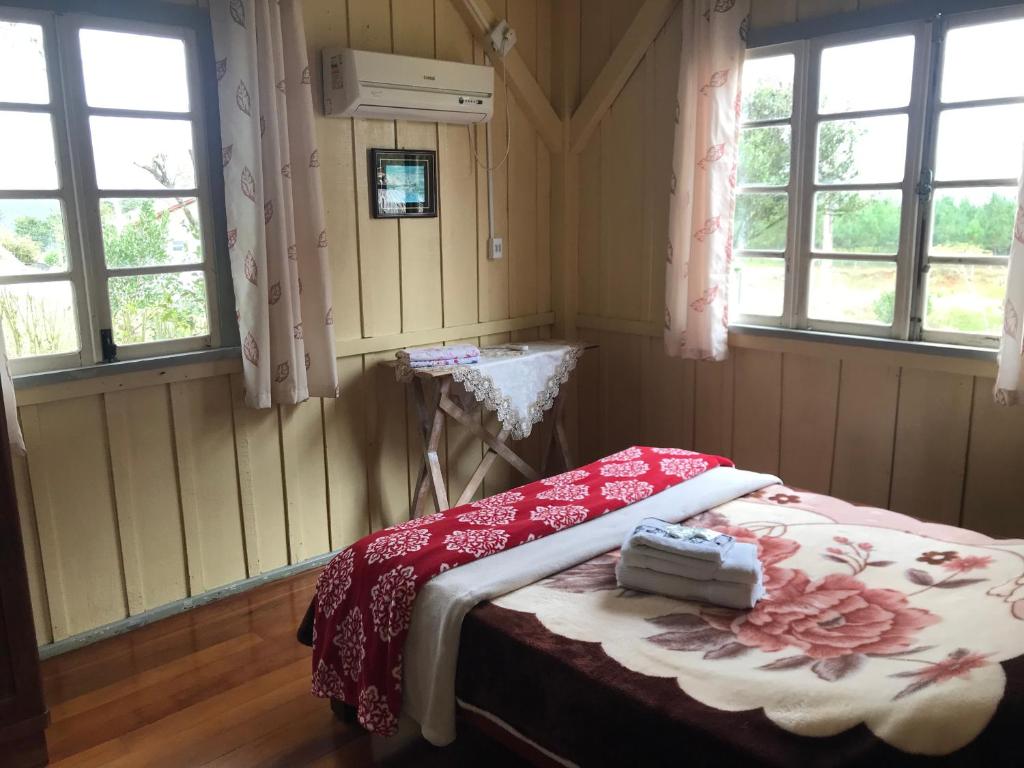 1 dormitorio con 1 cama en una habitación con ventanas en Gasthaus Heimat en Rio Forcação