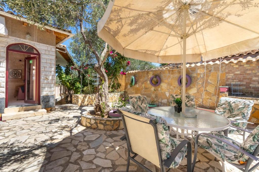 a patio with a table and an umbrella at Paco's Resort Luxury Villa 31 in Oziás