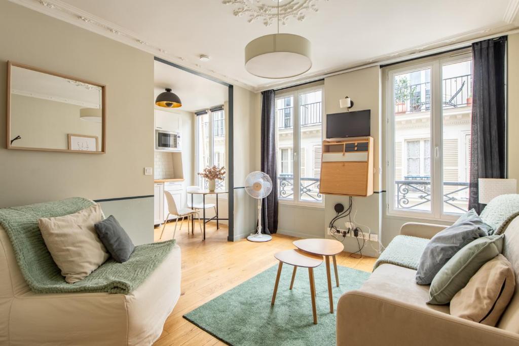 un salon avec un canapé et une table dans l'établissement Modern spacious studio only 1 minute away from the Place de la République, à Paris