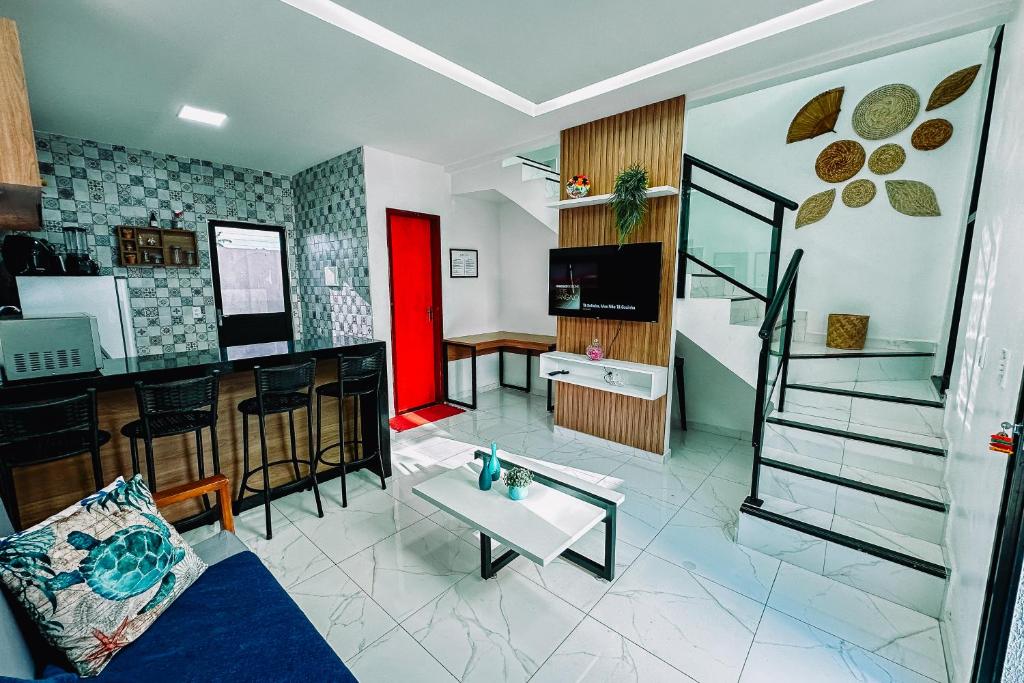 a living room with a staircase and a living room with a table at Casa Amar Cumbuco in Cumbuco