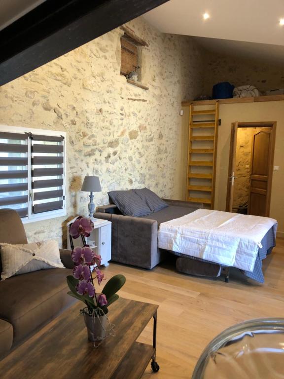 une chambre avec un lit, un canapé et une table dans l'établissement Le Pesquier, à Roquemaure
