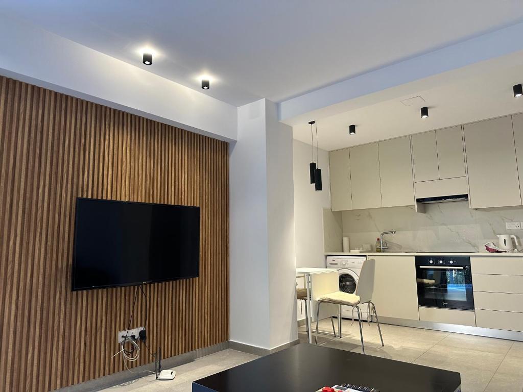 uma sala de estar com uma televisão de ecrã plano na parede em Royal Sunset Studios & Apartments em Limassol