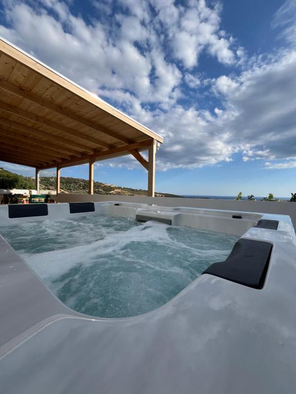 uma banheira de hidromassagem num pátio com telhado em Mano's House em Triopetra