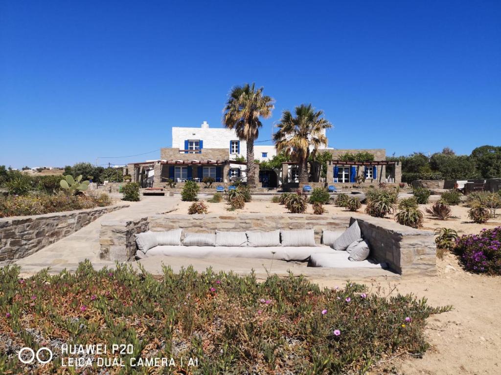 a couch sitting in the sand in front of a house at Villa Antinaxos in Ambelas