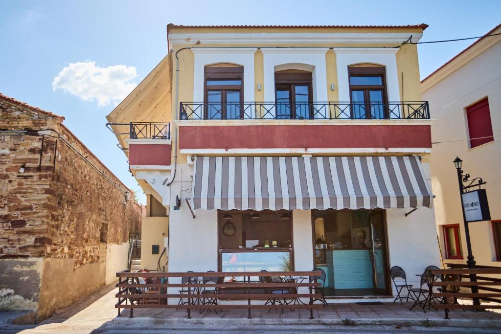 a restaurant with benches in front of a building at Windmills Apartments Chios in Chios