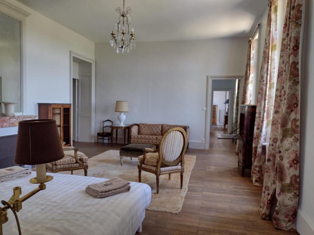 a bedroom with a bed and a living room at Castle Of Saint Germain Des Rives in Saint-Germain-des-Rives