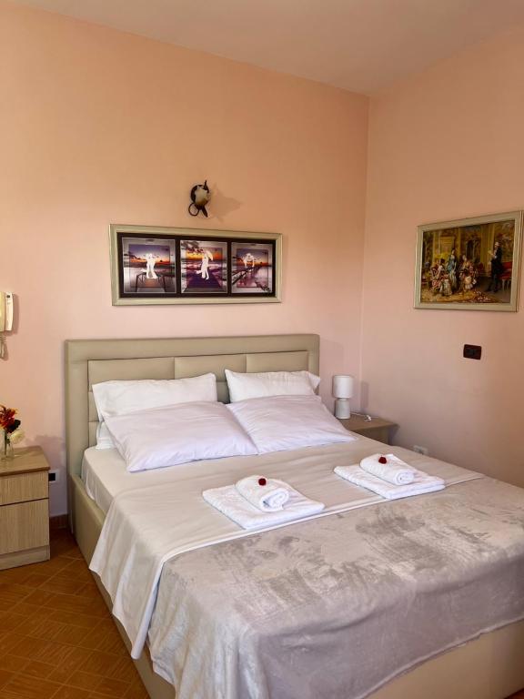 een slaapkamer met een bed met twee handdoeken erop bij Hotel Gega in Durrës