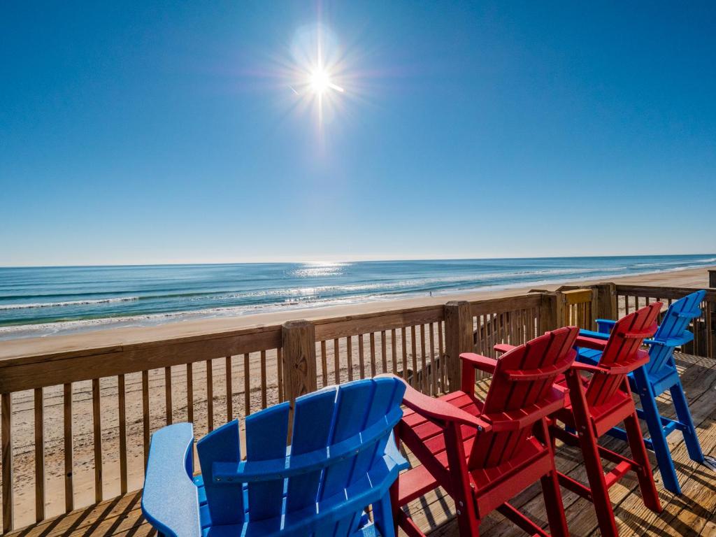 a row of blue and red chairs on the beach at Daybreak on the Sand in Surf City