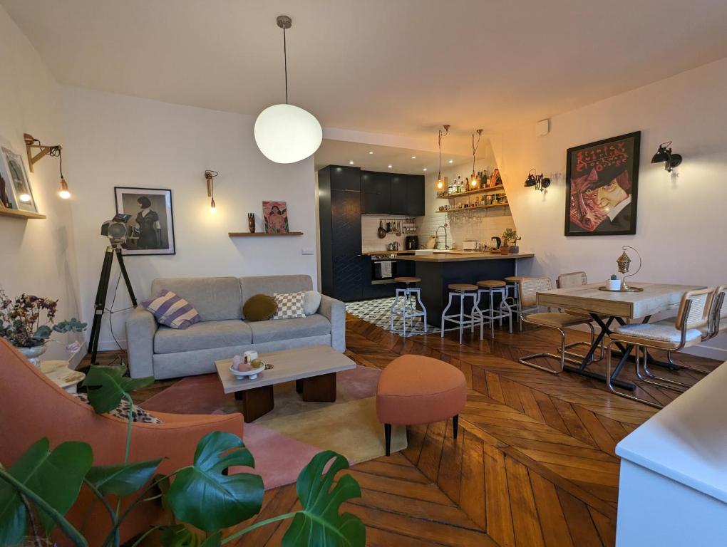 un salon avec un canapé et une table dans l'établissement Appartement élégant - Fbg Saint Denis, à Paris