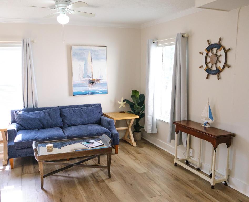 a living room with a blue couch and a table at Comfortable One Bedroom Apartment - Walk to the Beach! in Jacksonville Beach
