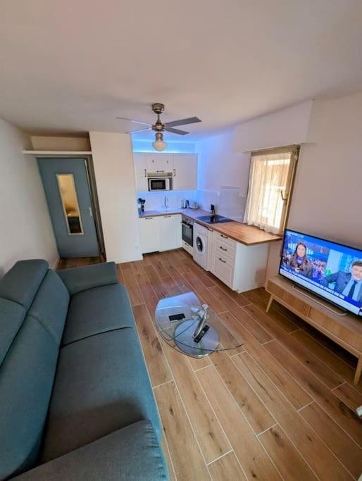 un salon avec un canapé et une cuisine dans l'établissement T2 à 200m de la mer et commerces, à Six-Fours-les-Plages