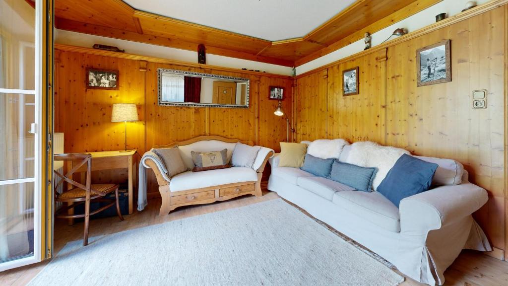 ein Wohnzimmer mit einem Sofa und einem Stuhl in der Unterkunft Chalet Kitzalp in Sankt Johann in Tirol