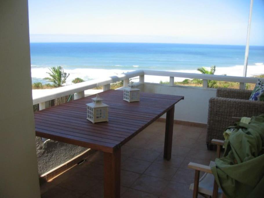una mesa de madera en un balcón con vistas al océano en Ocean views - 270 degrees, en Ericeira