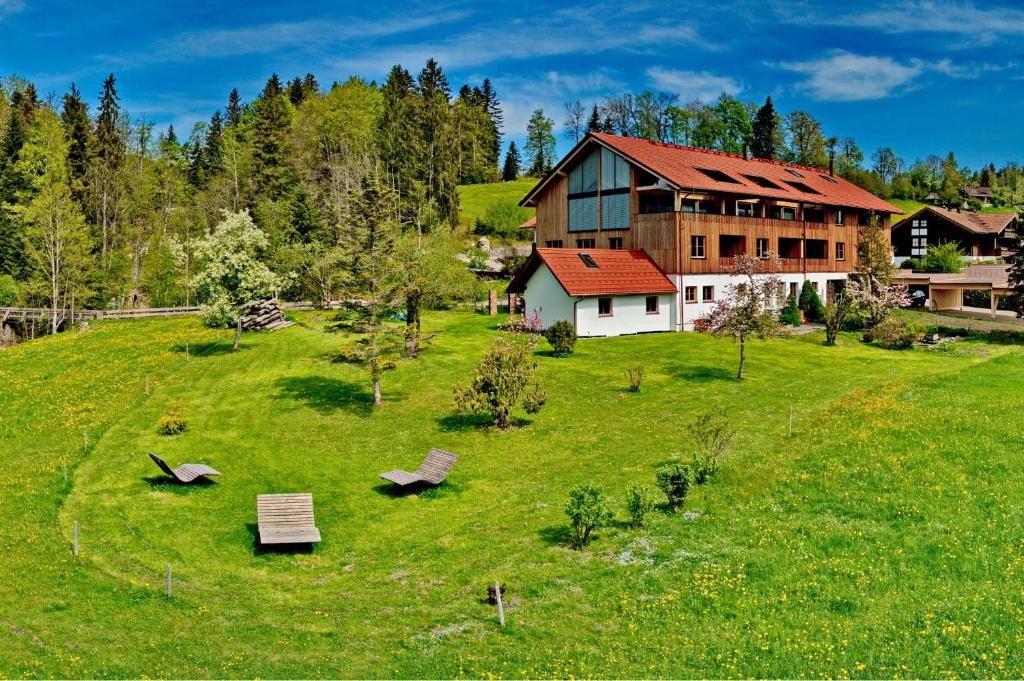 una casa su una collina con un campo verde di Eibele Chalets a Oberstaufen