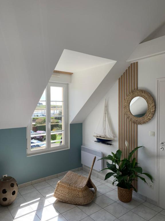 un salon avec une chaise et une fenêtre dans l'établissement Plein Soleil, à Barneville-Carteret