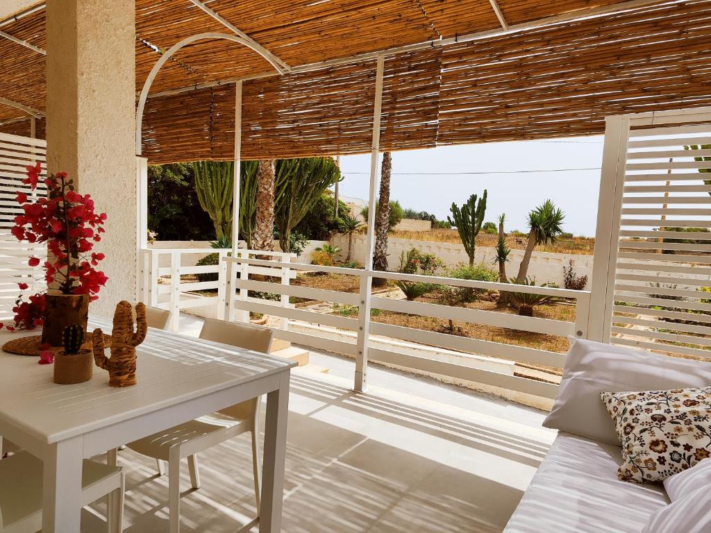 a living room with a table and a view of the desert at Sicilia Noto San Lorenzo Villa Amaranto in San Lorenzo
