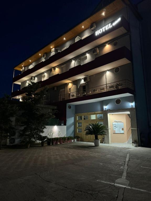 un edificio con un cartel en él por la noche en Hotel Kaloshi, en Tirana