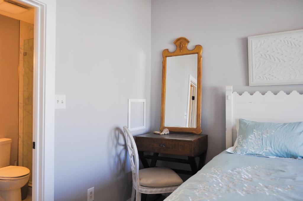 a bedroom with a bed and a mirror and a chair at Doves Landing in Surf City