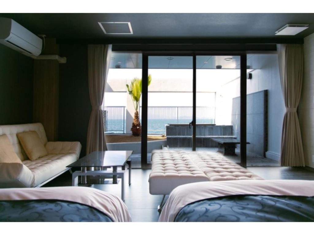 Habitación con 2 camas, sofá y ventana en Setouchi Resort Hotel - Vacation STAY 95869v, en Matsuyama