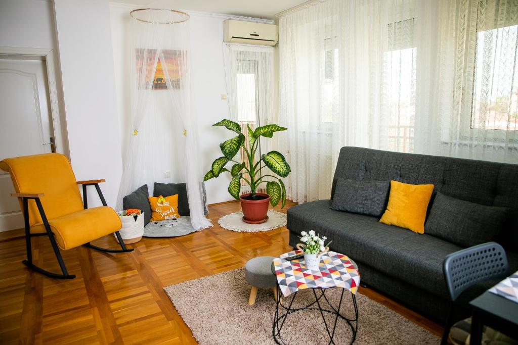 een woonkamer met een bank en een tafel bij Lena`s Home in Subotica