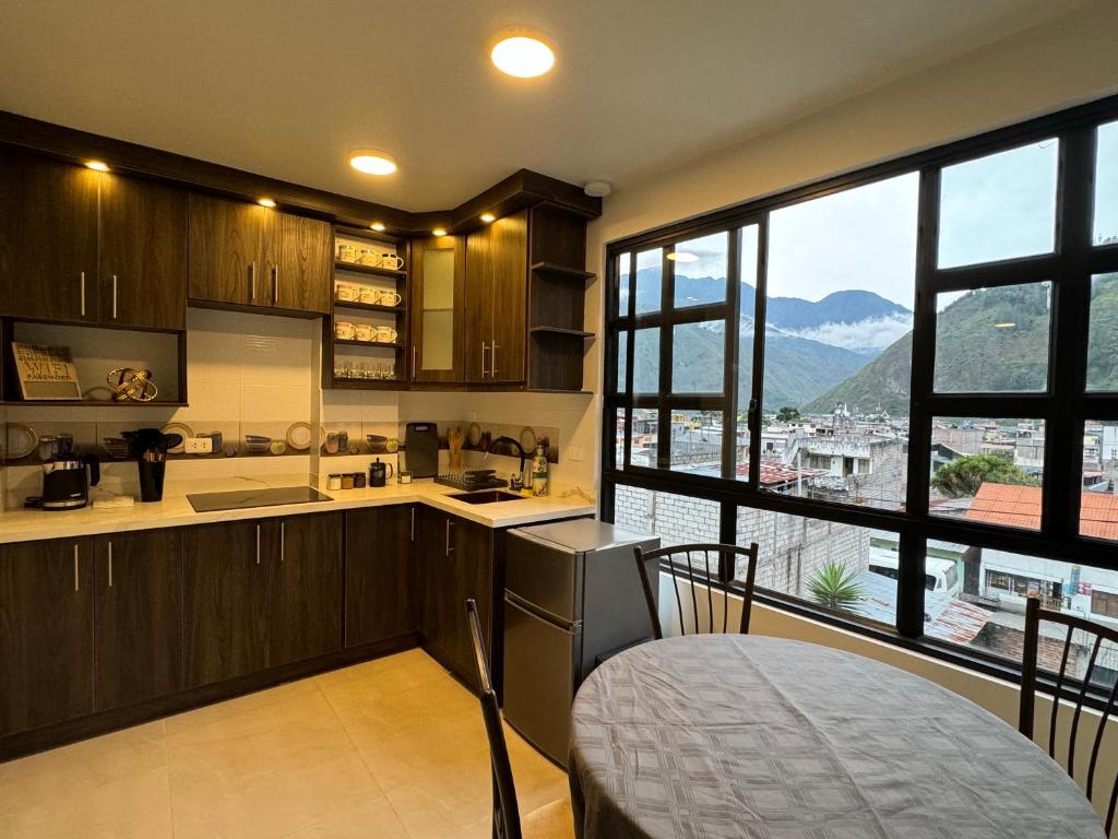 a kitchen with wooden cabinets and a large window at Presidencial Penthouse - 2 Bedrooms 3 Bath in Baños