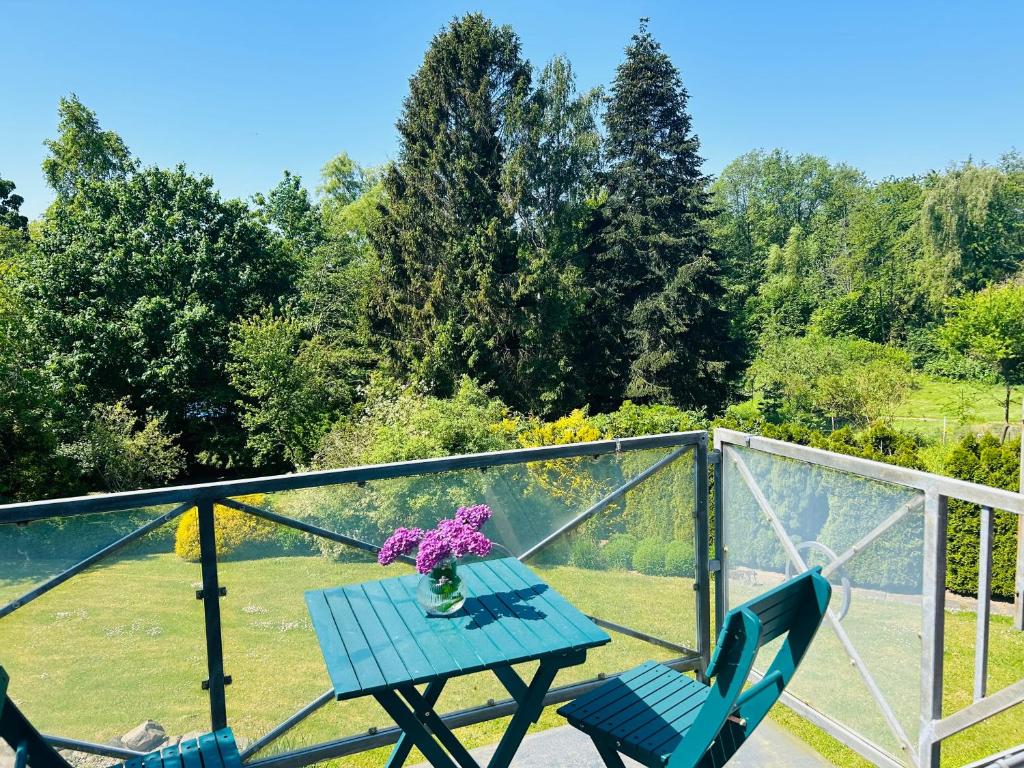 a table with a vase of flowers on a balcony at Fördeliebe in Heikendorf