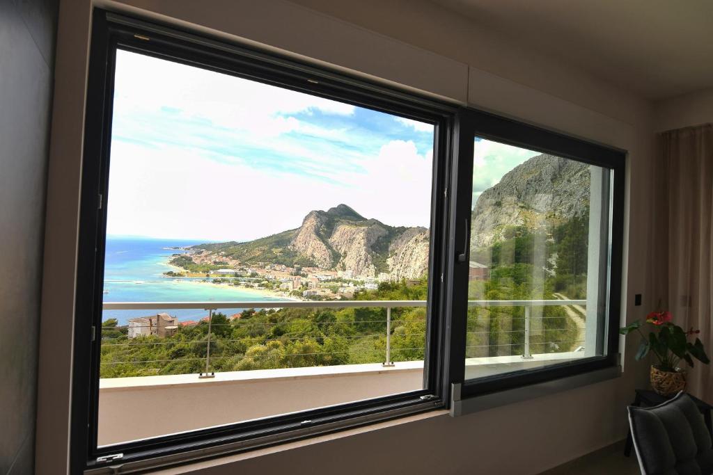 a window with a view of the ocean and mountains at Casa Miele in Omiš