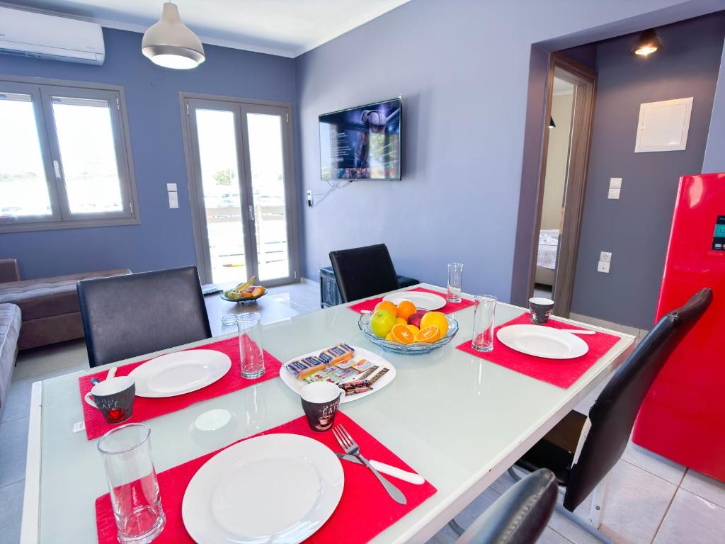 a dining room with a white table with red accents at Elafonisi Paradise with Parking, WiFi, - Walking Distance to the Beach in Elafonisi