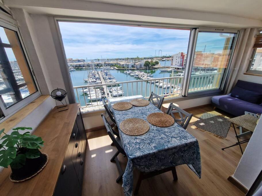 Cette chambre dispose d'une table et offre une vue sur le port. dans l'établissement Appartement Cap d'Agde avec vue mer, au Cap d'Agde