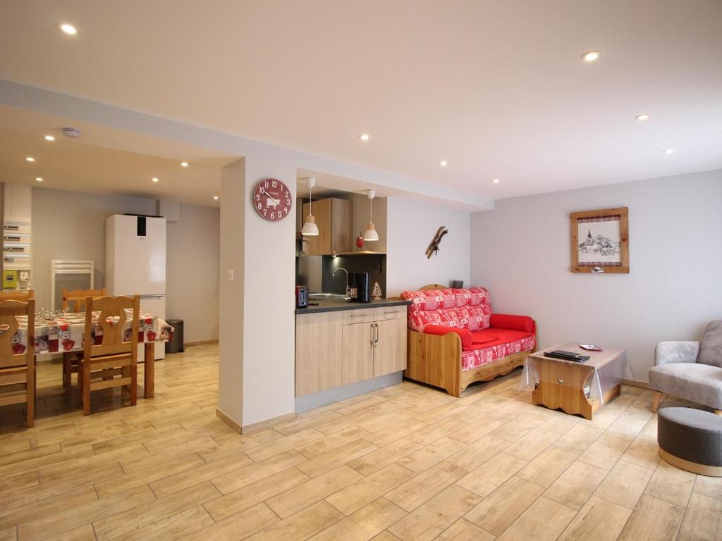 un salon avec un canapé rouge et une cuisine dans l'établissement Charmant T2 au Mont-Dore, parking privatif, proche thermes, classé 2 étoiles - 4 couchages - FR-1-415-124, à Le Mont-Dore