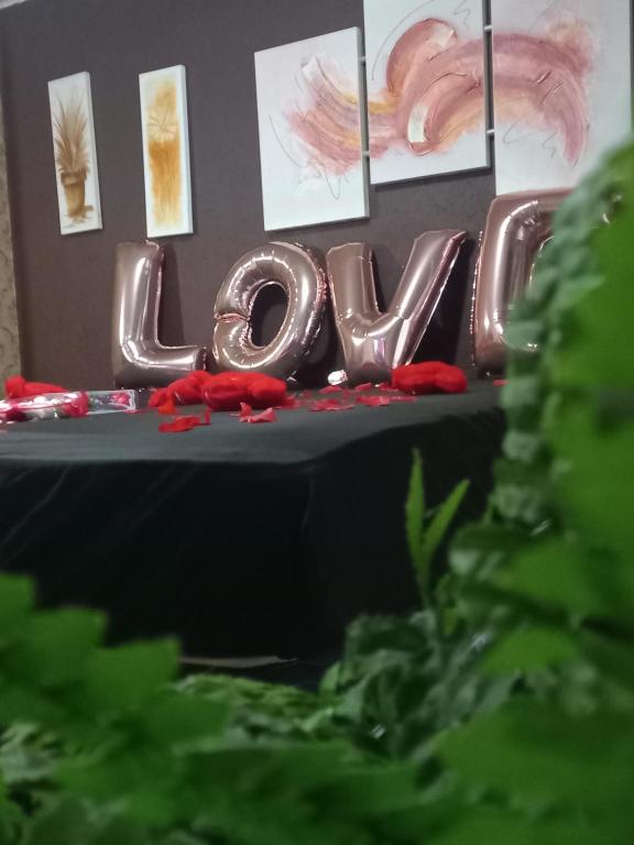 una señal que dice amor en una mesa con flores rojas en Suites no Casarão Refugio da Serra, 4km do Centro turístico, en Campos do Jordão