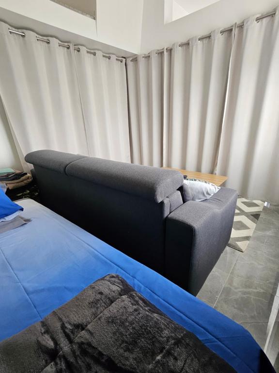 a couch and a bed in a room with curtains at bienvenue chez Alain et Marie in Antibes