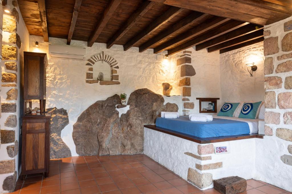a room with a bed in a stone wall at Villa Margarita Studio in Patmos