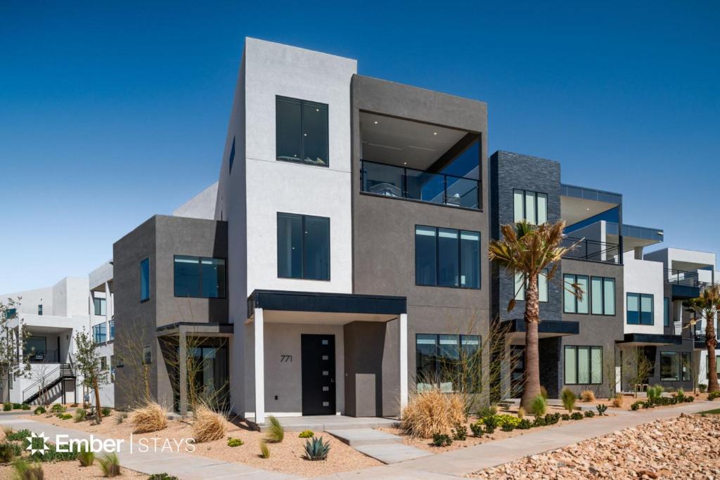a large building with a palm tree in front of it at Desert Dream at Desert Color (by Ember Stays) in St. George